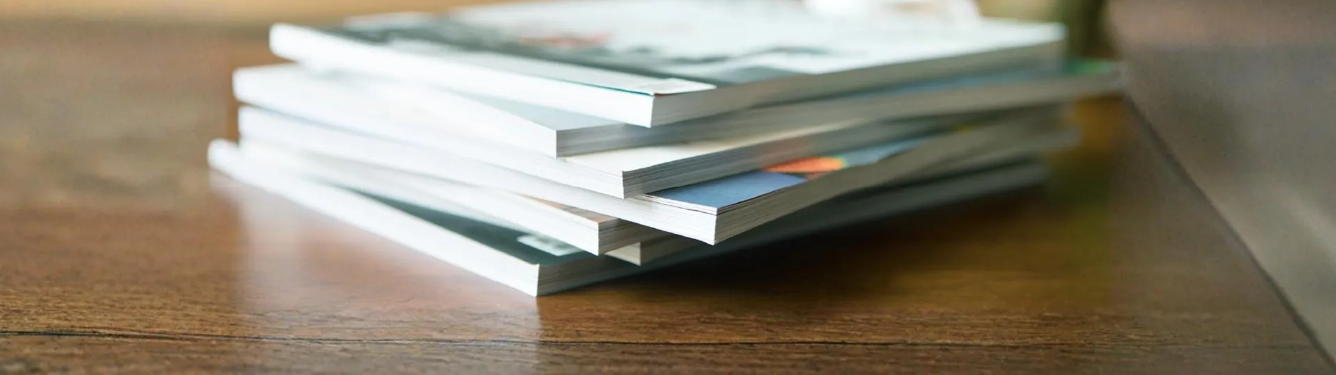 Stapel von Dokumenten und Unterlagen auf Holztisch, symbolisiert strukturierte Organisation, Informationsmanagement und professionelle Arbeitsweise bei ProKanzlei.