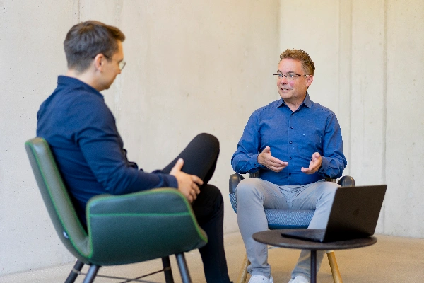 Zwei Personen analysieren gemeinsam Diagramme und Unterlagen am Tisch und entwickeln Strategien mit umfassendem 360°-Blick für fundierte Entscheidungen.