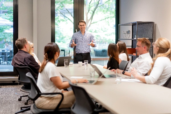 Geschäftsteam diskutiert Strategien und Unterlagen am Konferenztisch im Büro und entwickelt gemeinsam durchdachte Individuallösungen für Unternehmensentscheidungen.