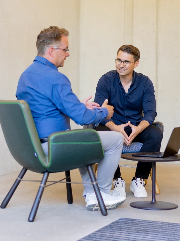Zwei Berater analysieren gemeinsam Daten auf einem Tablet und besprechen strategische Maßnahmen zur Kanzleientwicklung im Rahmen von ProKanzlei.